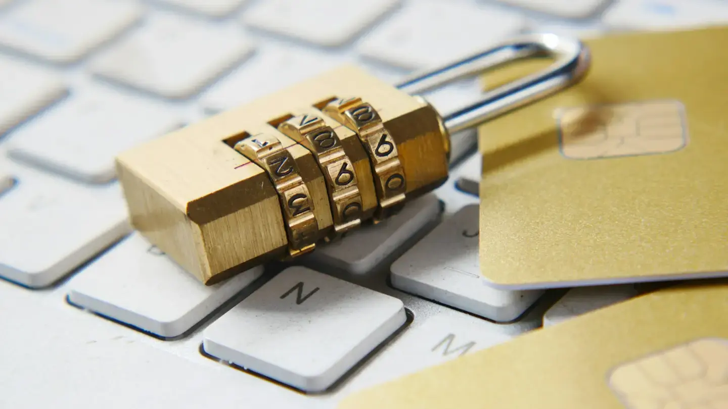 Cadenas à combinaison doré posé sur un clavier d’ordinateur blanc