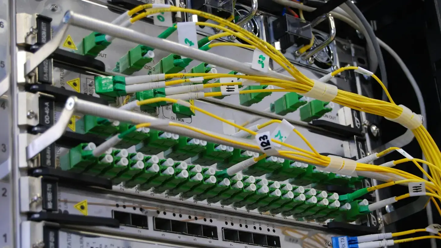 Câbles de fibre optique jaunes branchés sur un équipement réseau dans une baie