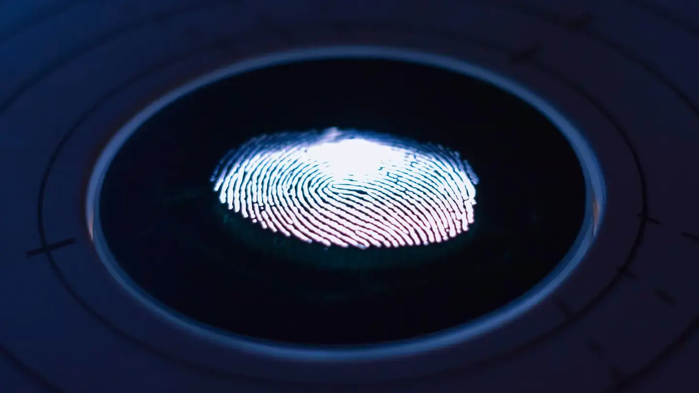 Empreinte digitale lumineuse au centre d’un lecteur circulaire sombre