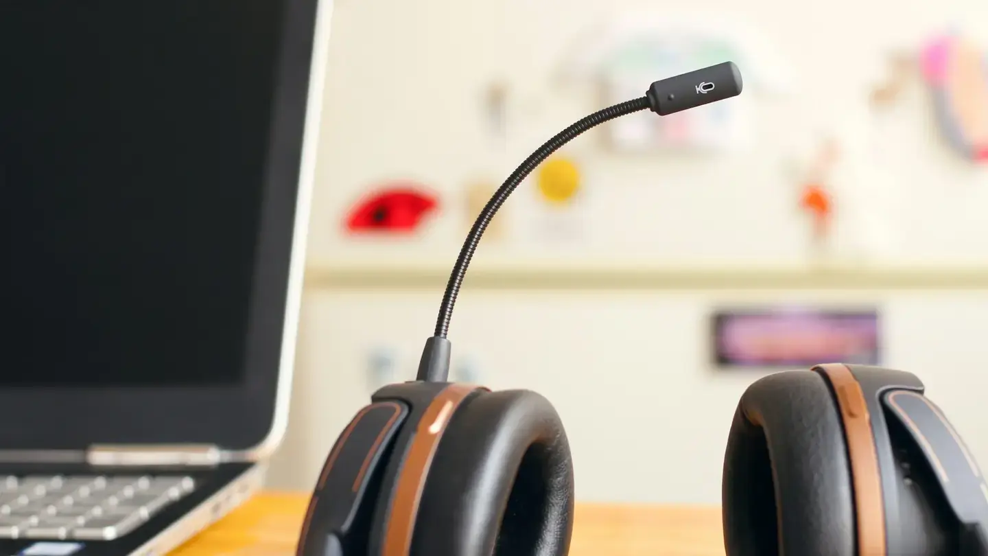 Casque micro de conseiller posé sur un bureau à côté d’un ordinateur portable