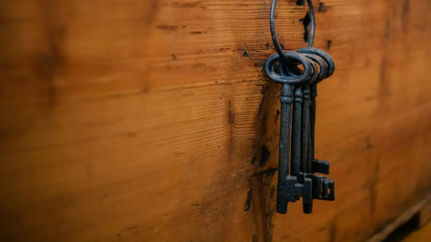 Trousseau d’anciennes clés en fer suspendu contre une façade en bois