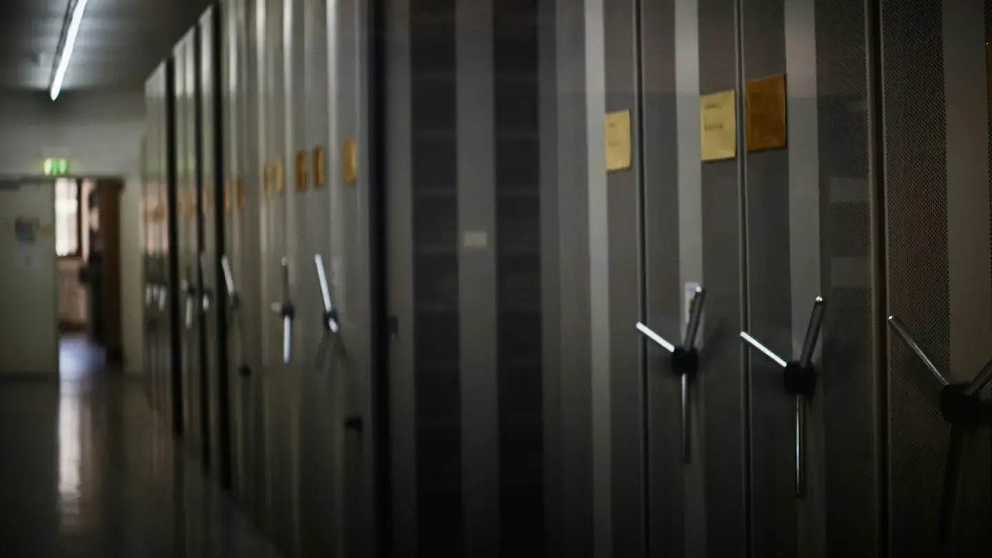 Allée d’armoires d’archives mobiles à volants dans un couloir faiblement éclairé