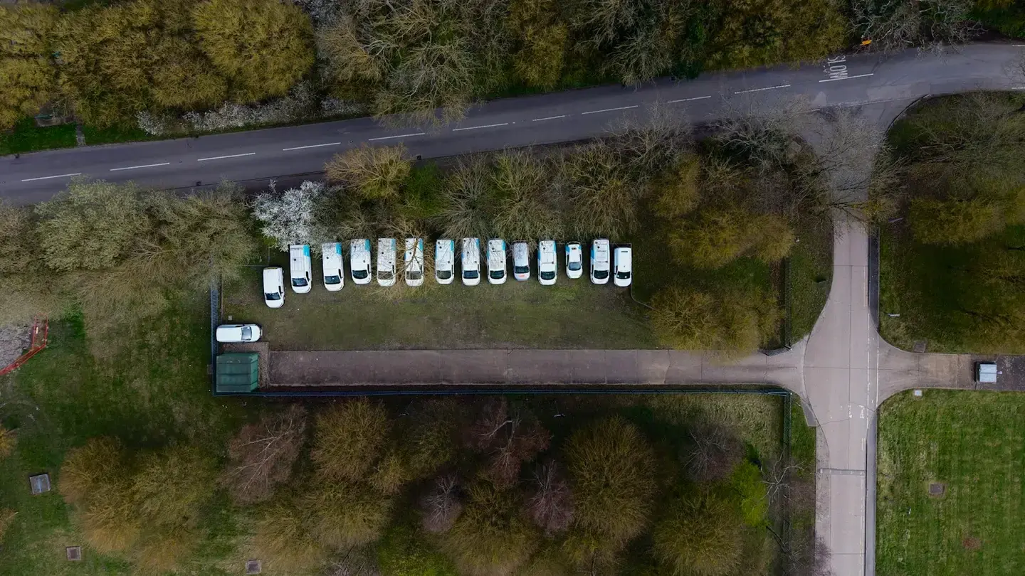 Vue aérienne d’une rangée de fourgonnettes blanches garées le long d’une route