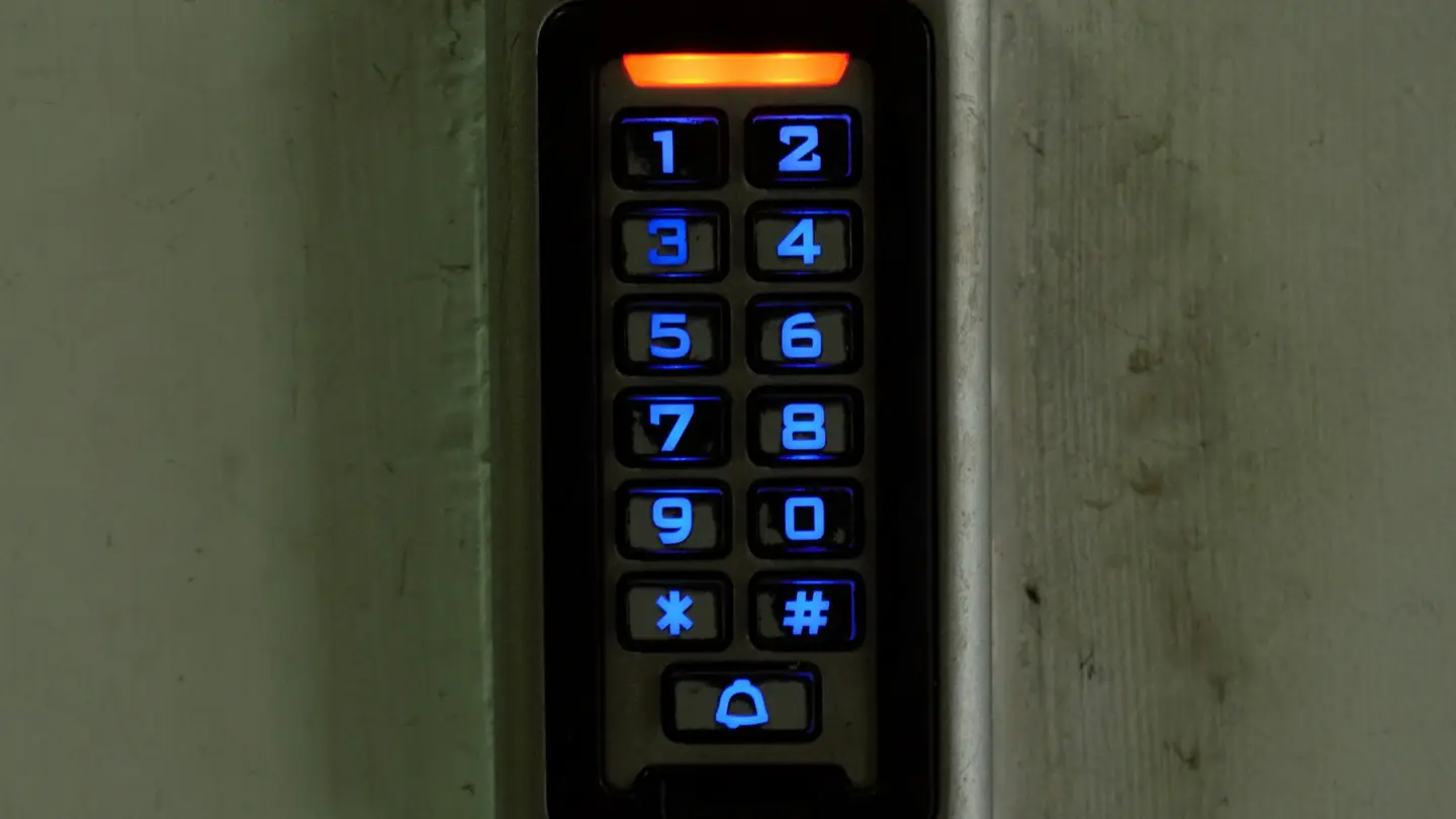 Clavier à code lumineux fixé au mur à côté d’une porte