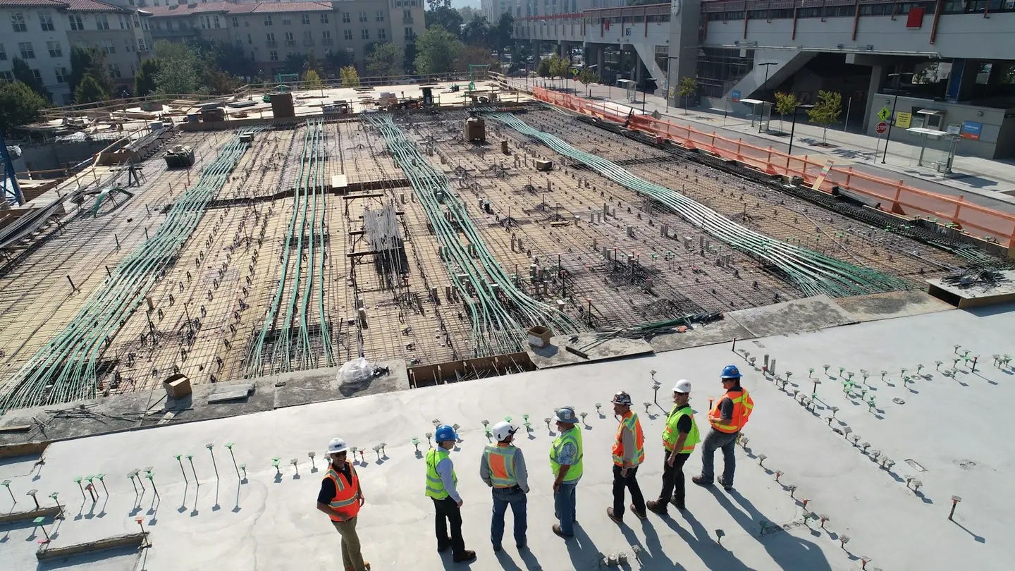 Équipe de chantier en gilets haute visibilité sur une vaste dalle en cours de ferraillage