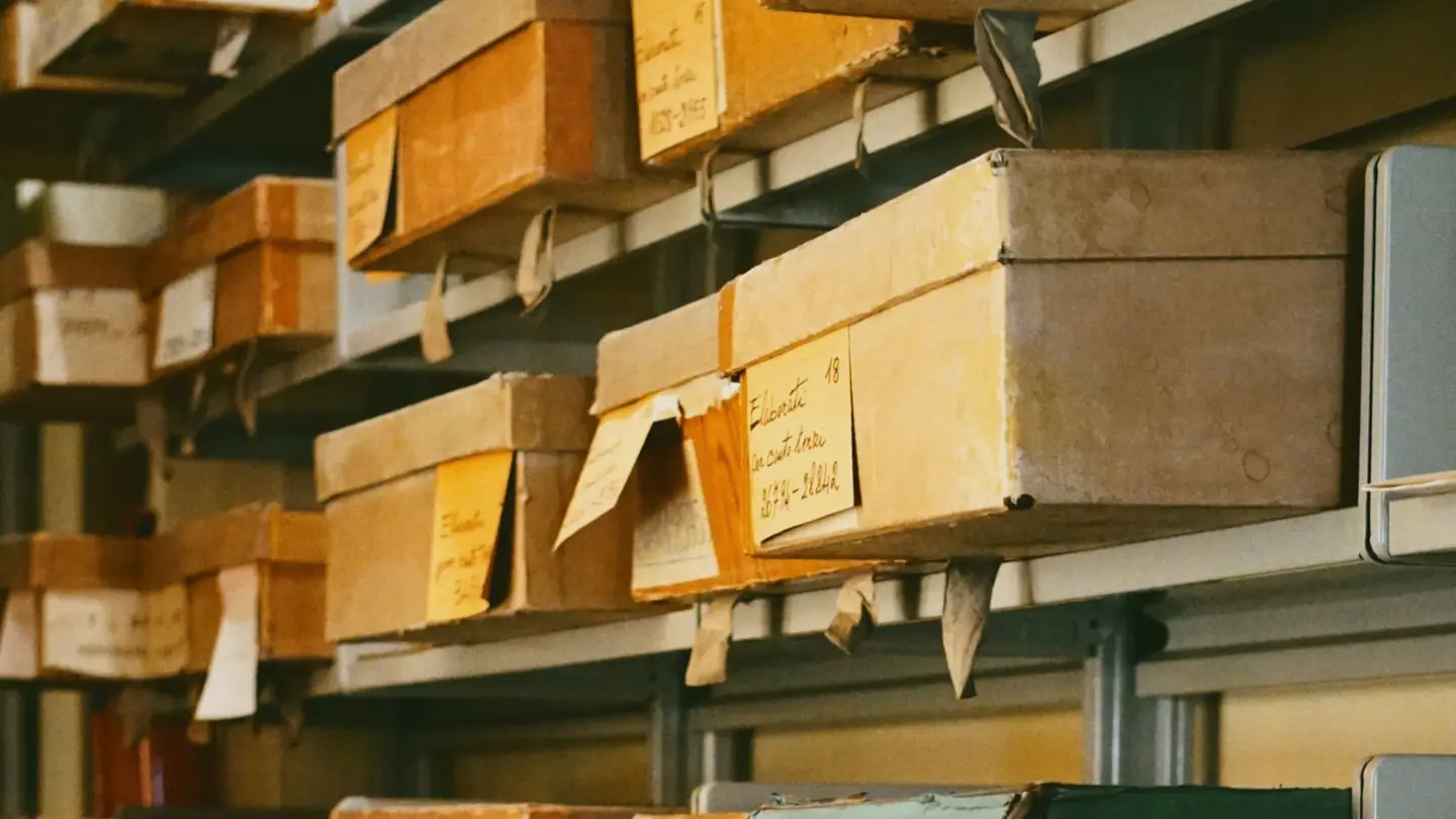 Étagères d’archives chargées de boîtes étiquetées à la main