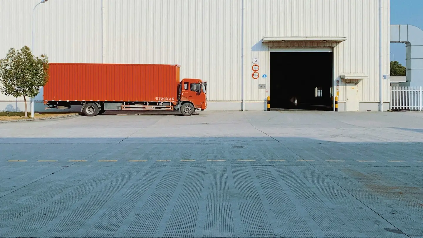 Camion porteur stationné devant un quai de chargement d’entrepôt