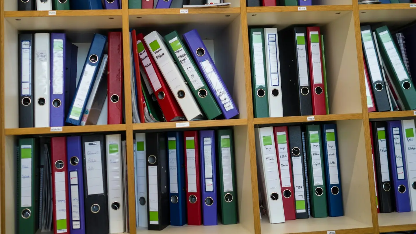 Étagères remplies de classeurs colorés étiquetés à la main