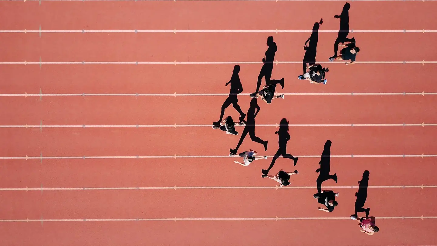 Vue aérienne de coureurs sur une piste d’athlétisme, chacun dans son couloir