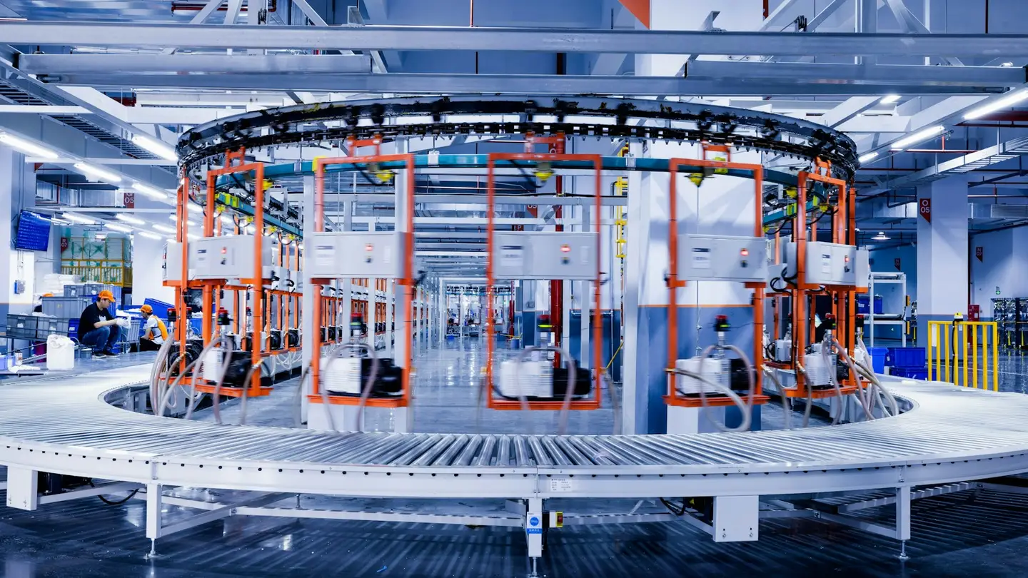 Opérateurs travaillant autour d’une ligne d’assemblage circulaire dans un atelier lumineux