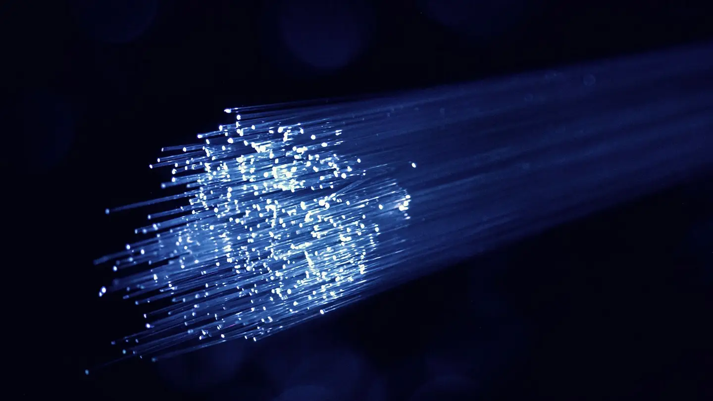 Faisceau de fibres optiques lumineuses sur fond sombre