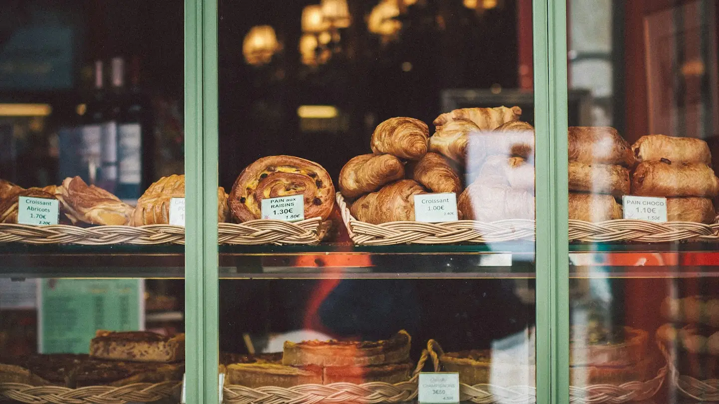 Vitrine d’une boulangerie avec croissants et pains aux raisins étiquetés