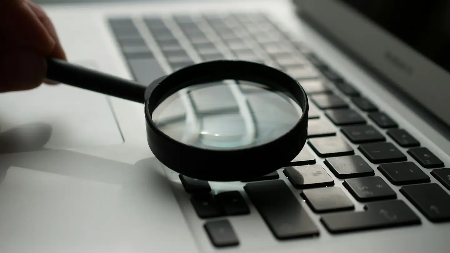 Loupe tenue au-dessus du clavier d’un ordinateur portable